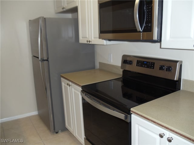 kitchen featuring white cabinetry, stainless steel appliances, and light tile patterned floors