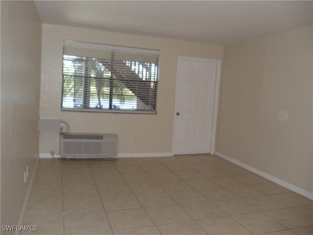 unfurnished room featuring a wealth of natural light, a wall unit AC, and light tile patterned floors