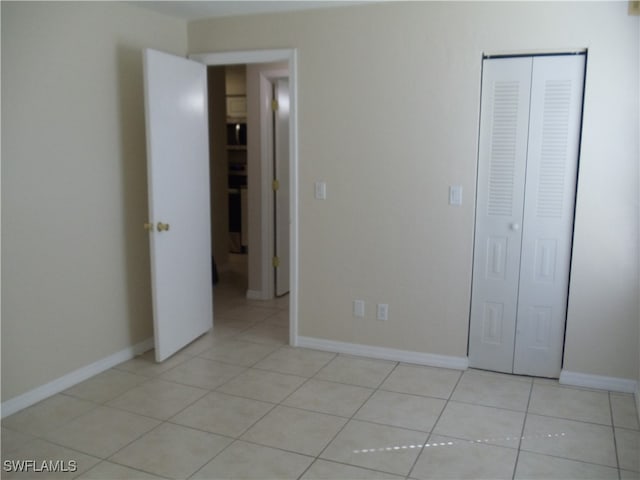 unfurnished bedroom with a closet and light tile patterned floors