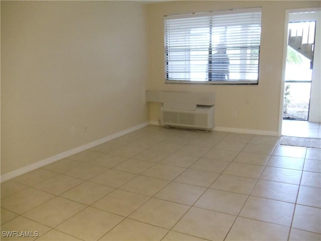 unfurnished room with light tile patterned floors and baseboards