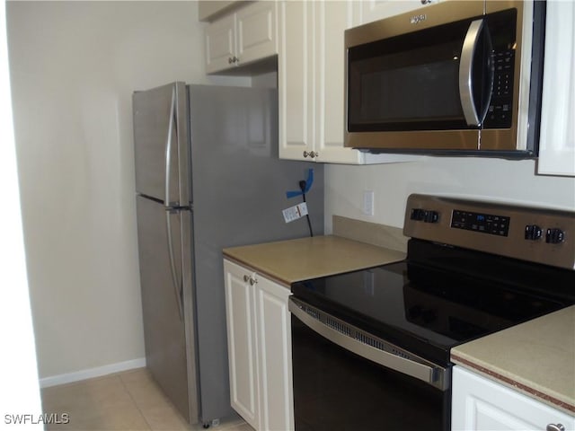 kitchen featuring white cabinets, stainless steel appliances, light countertops, and light tile patterned flooring