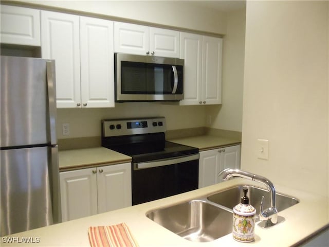 kitchen featuring white cabinetry, appliances with stainless steel finishes, light countertops, and a sink