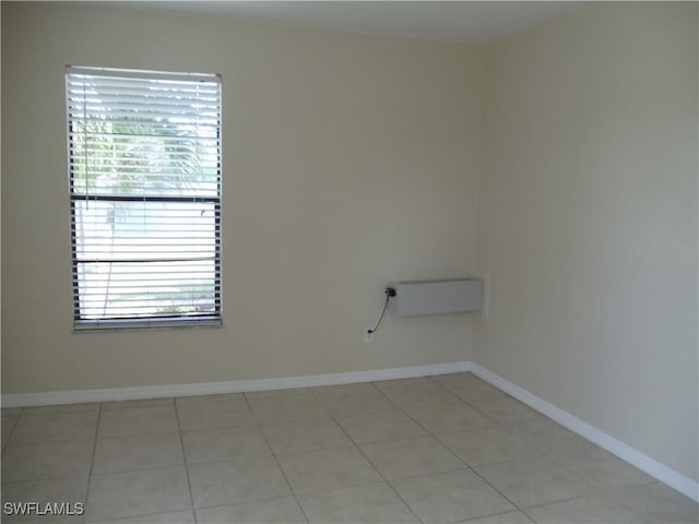 spare room with light tile patterned floors and baseboards