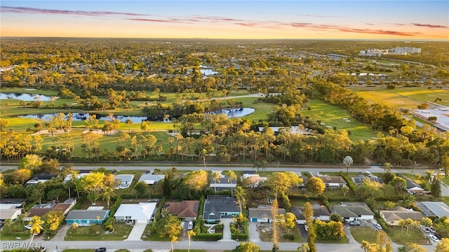 aerial view at dusk featuring a water view