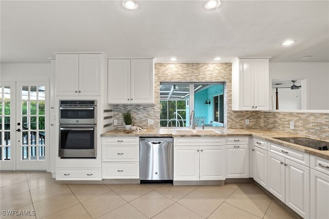 kitchen featuring sink, white cabinetry, stainless steel appliances, and a wealth of natural light