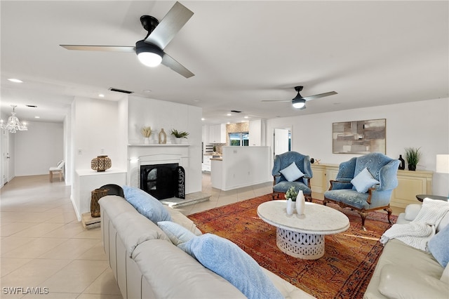 living room with ceiling fan with notable chandelier and light tile patterned floors