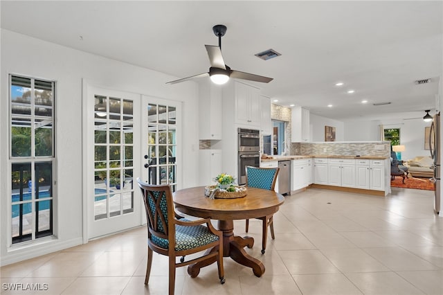 dining area with ceiling fan, light tile patterned flooring, and french doors