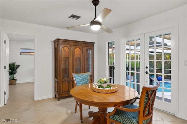 tiled dining room with ceiling fan and french doors