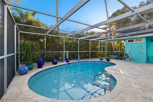 view of swimming pool with a patio and a lanai