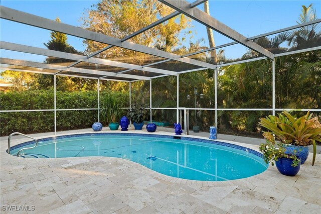 view of pool featuring glass enclosure and a patio