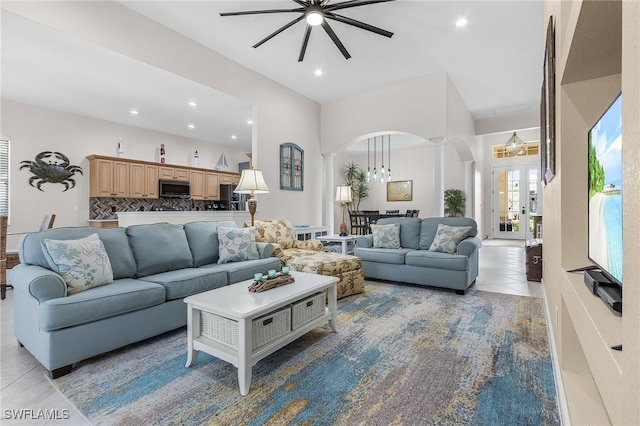 living room with ceiling fan with notable chandelier and light tile patterned floors