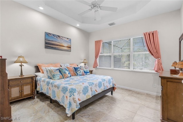 bedroom featuring ceiling fan and a raised ceiling