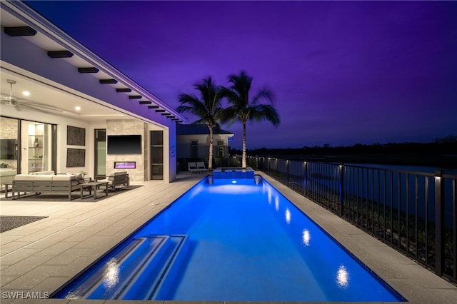 pool at dusk with an outdoor hangout area