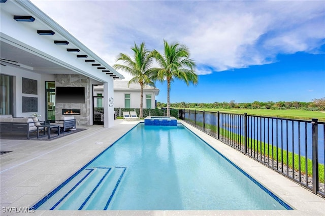 view of swimming pool with a water view, a patio area, and an outdoor living space with a fireplace