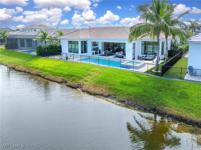 back of property featuring a patio area, a yard, and a water view