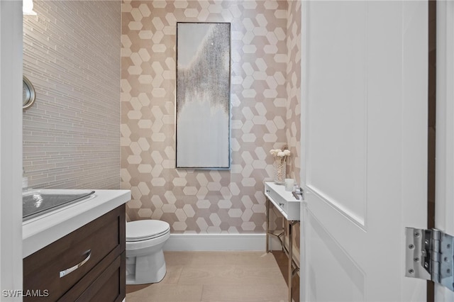 bathroom featuring toilet, vanity, and tile patterned flooring