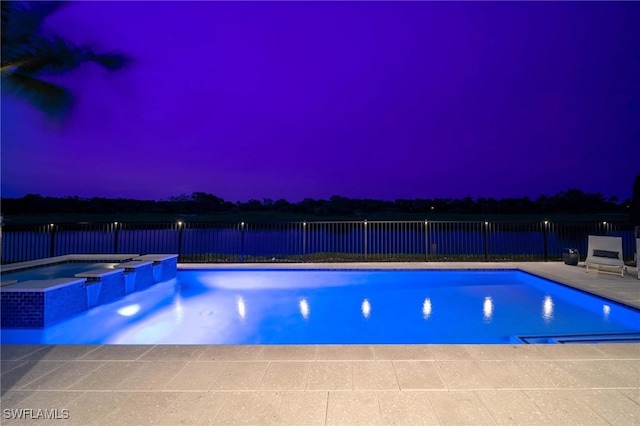 pool at dusk with a patio area