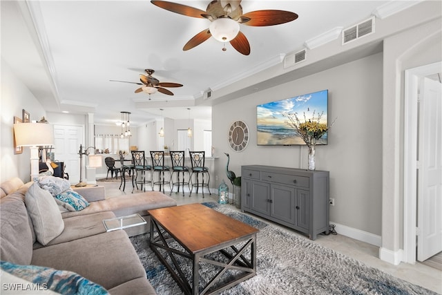 living room with ornamental molding and ceiling fan