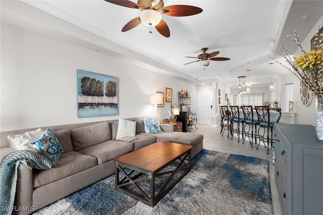 living room with crown molding, tile patterned floors, and ceiling fan with notable chandelier