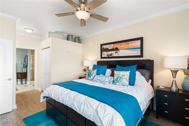 bedroom with a closet, ornamental molding, hardwood / wood-style floors, and ceiling fan