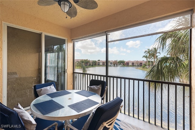 sunroom featuring a water view and ceiling fan