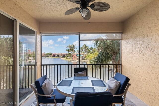 sunroom / solarium featuring a water view and ceiling fan