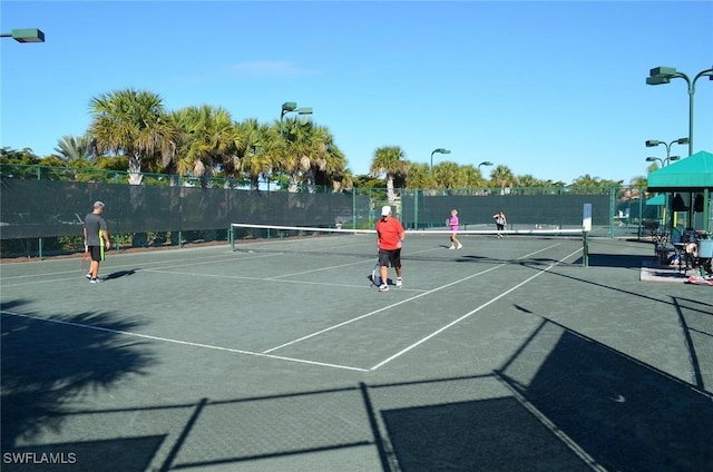 view of tennis court featuring fence and community basketball court
