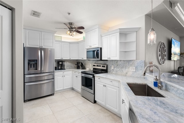 kitchen with sink, white cabinetry, stainless steel appliances, pendant lighting, and light stone counters