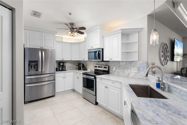 kitchen featuring open shelves, appliances with stainless steel finishes, a sink, decorative backsplash, and visible vents