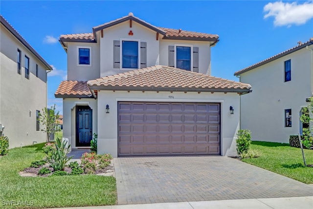 mediterranean / spanish house featuring a front yard and a garage