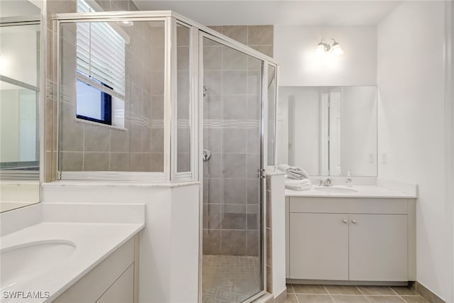 bathroom featuring tile patterned flooring, vanity, and a shower with door