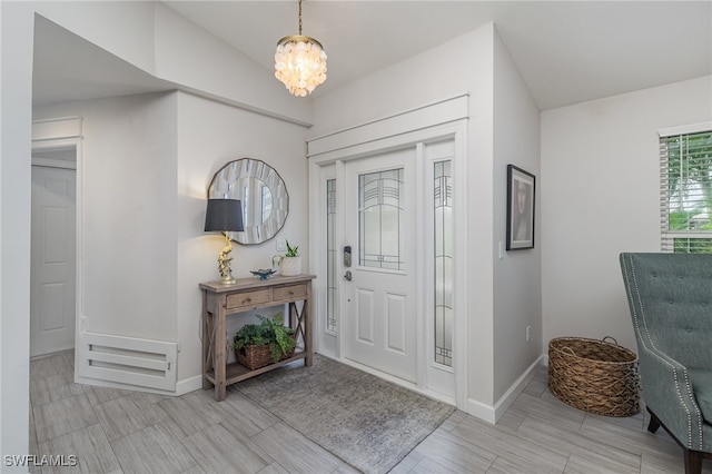 foyer with a chandelier and vaulted ceiling