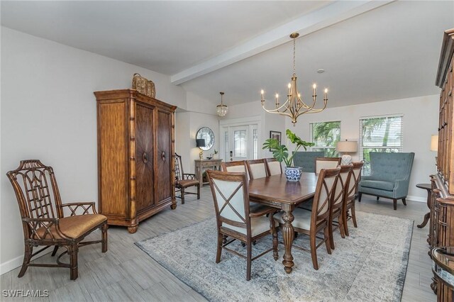 dining room featuring light wood-type flooring, lofted ceiling with beams, and an inviting chandelier