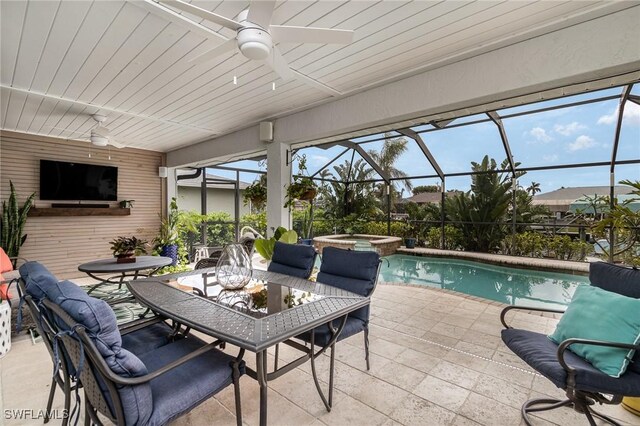 exterior space with a swimming pool with hot tub, ceiling fan, and a lanai