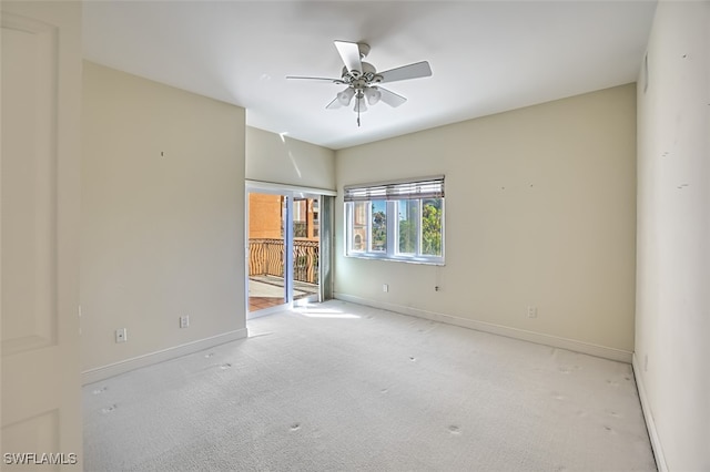 carpeted spare room with ceiling fan