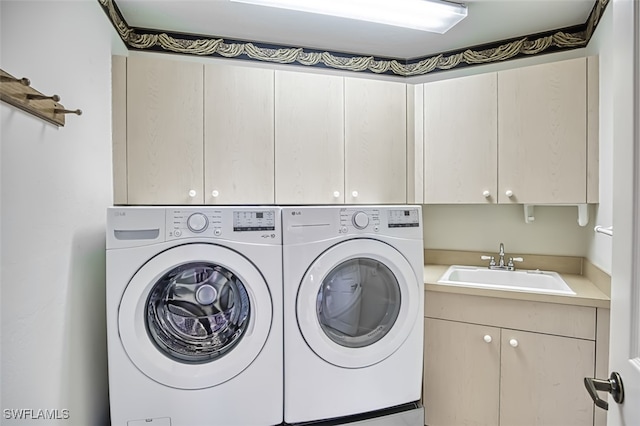 washroom with cabinets, sink, and washing machine and dryer