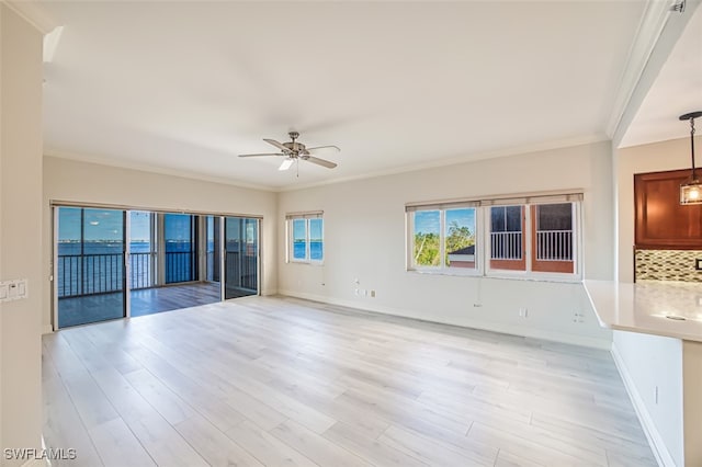 spare room featuring light wood-type flooring, ceiling fan, and ornamental molding