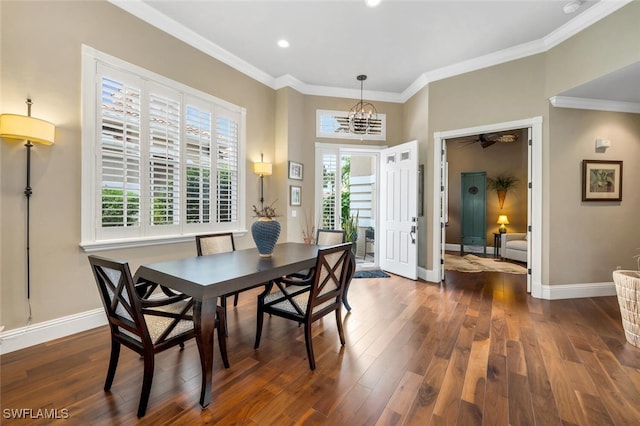 dining area featuring dark wood-type flooring, ornamental molding, and an inviting chandelier