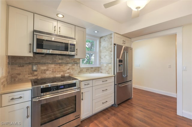 kitchen featuring white cabinets, tasteful backsplash, ceiling fan, appliances with stainless steel finishes, and dark wood-type flooring