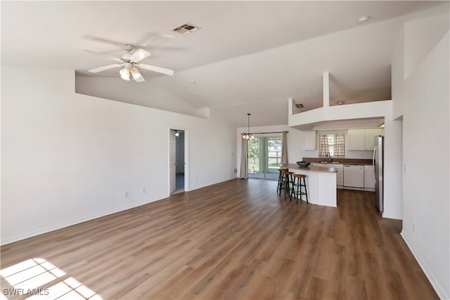 unfurnished living room featuring high vaulted ceiling, dark wood-type flooring, ceiling fan, and sink