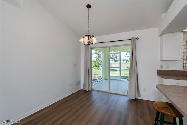 unfurnished dining area with dark wood-type flooring and a chandelier