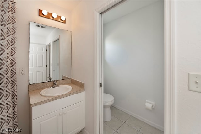 bathroom featuring toilet, vanity, and tile patterned floors