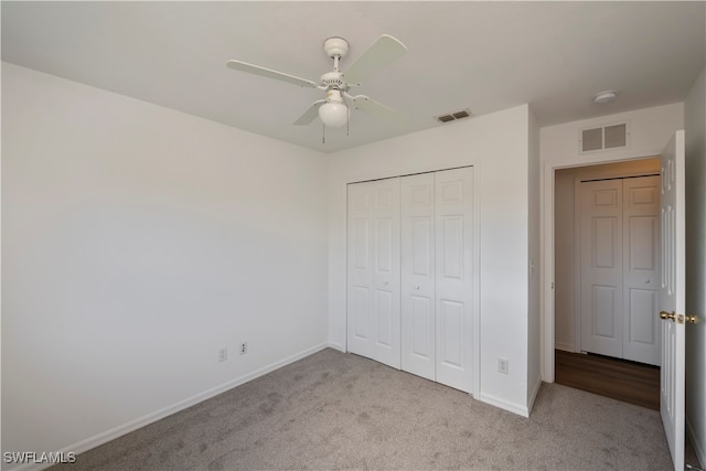 unfurnished bedroom with a closet, light colored carpet, and ceiling fan