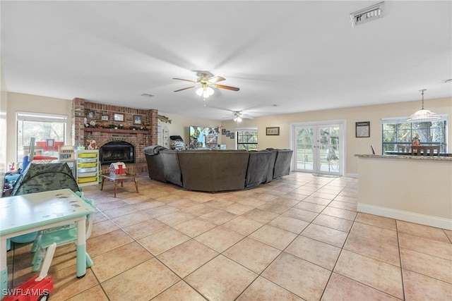 tiled living room with a brick fireplace and ceiling fan