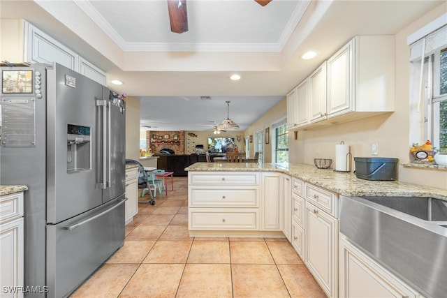 kitchen with kitchen peninsula, ornamental molding, high quality fridge, and a fireplace