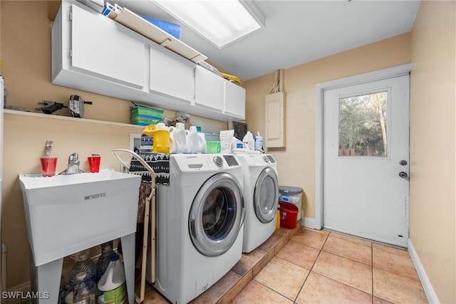 laundry room featuring light tile patterned floors, electric panel, cabinets, and washing machine and clothes dryer