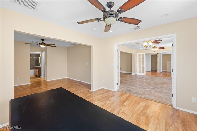 unfurnished living room with light hardwood / wood-style floors and french doors