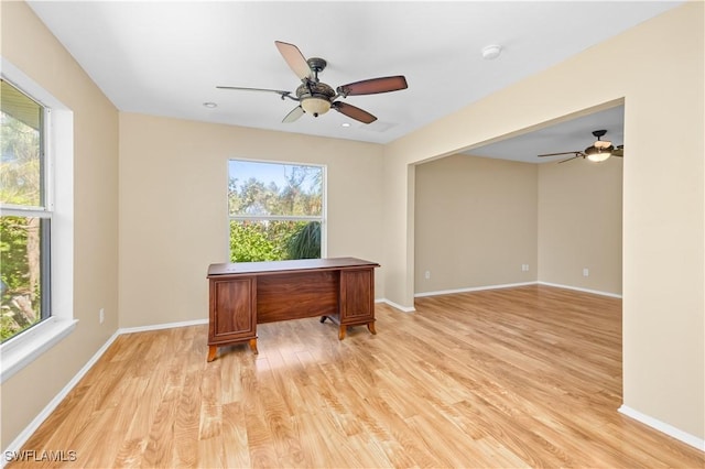 home office with light hardwood / wood-style floors and ceiling fan