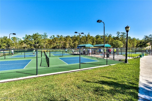 view of sport court with a lawn