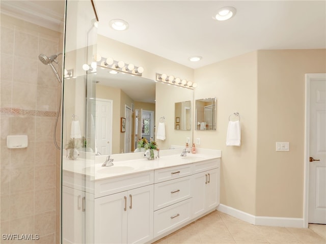 bathroom featuring vanity, tile patterned flooring, and a tile shower